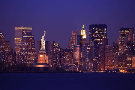 Statue Of Liberty In Front Of Manhattan Skyline At Night Photograph By