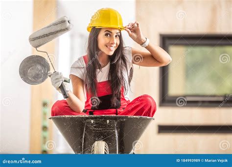 Beautiful Girl Sitting In A Wheelbarrow Inside The Construction Site
