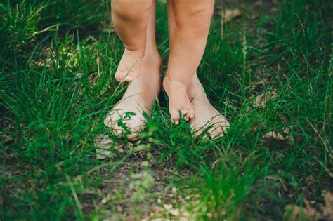 Legs Of Mother And Her Baby Walk On Ground Barefoot In Backyard Stock