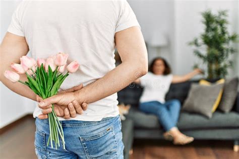 man surprising his wife with flowers at home stock image image of flower husband 244273133