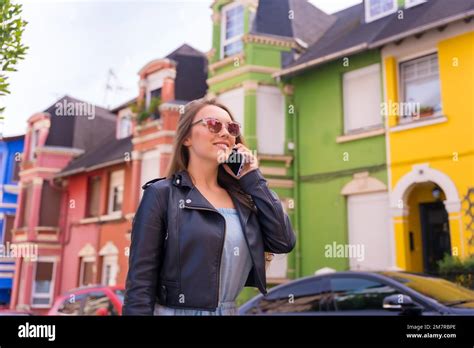 Young blonde woman in leather jacket walking visiting the neighborhood