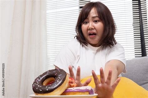 Chubby Asian Woman Try To Stop Herself From Eating Donut Stock Photo Adobe Stock