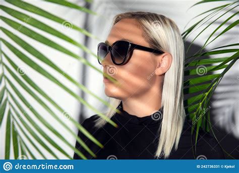 Profile Of Beautiful Woman With Sunglasses Hiding Behind Tropical Palm Leaves Stock Image