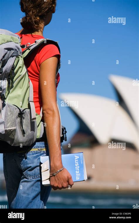 Backpacker Holding Guidebook With Sydney Opera House In Background