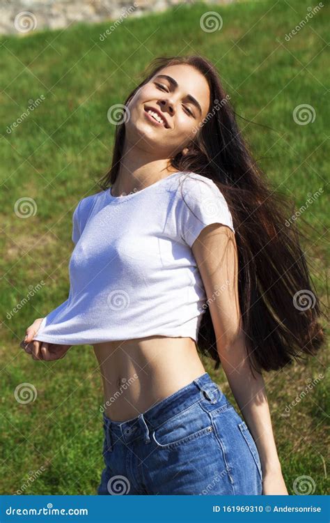 junge schöne teenagermädchen die gegen den sommerpark posieren helles sonniges wetter