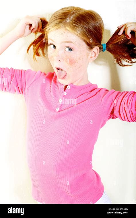 Young Girl With Freckles And Red Hair In Pigtails Poses In The Stock