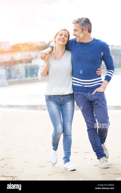 Middle Aged Couple Walking On The Beach Full Length Stock Photo Alamy