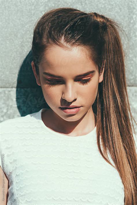 Sunlit Portrait Of A Young Woman Looking Down By Aleksandra Kovac Beauty Portrait Stocksy