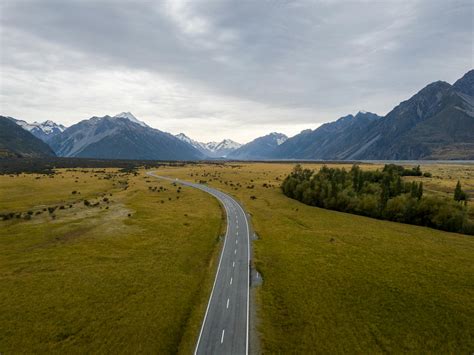 Asphalt Road Through Green Valley Towards High Mountains · Free Stock Photo