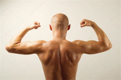 Rear View Of Muscular Man Showing His Back Muscles Stock Photo By ©big
