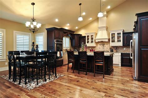This chic and polished kitchen is full of stunning woodwork, both in the the wooden floors are a rich dark color, with natural texture and hues. The Medallion 4600 Kitchen | Beautiful wood flooring and multi colored cabinets. Hood over range ...