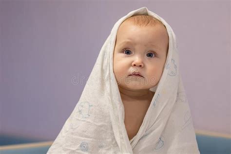 Shocked Baby Girl Covered With Towel Sits Waiting For Parent Stock