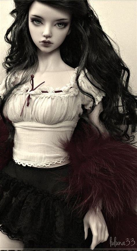 A Doll With Long Black Hair Wearing A White Top And Red Fur Stoler On