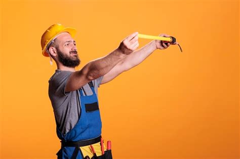 premium photo confident construction worker using tape measure to take measurements and work