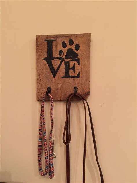 A Couple Of Leashes Hanging On A Wall With A Dogs Love Sign