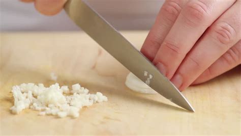A Garlic Clove Being Peeled And Finely Chopped Stock Footage Video