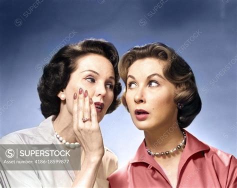 1950s 1960s Two Nosey Women Gossiping One Whispering Into The Others