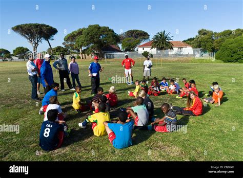 Football Coaches Instructing A Young Players During A Training Session