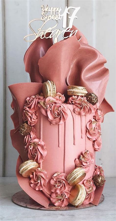 A Pink Cake With Gold Decorations On Top
