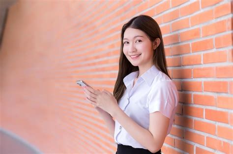 Retrato De Estudiante Asi Tica Tailandesa En Uniforme Est Sonriendo Mientras Usa El Tel Fono