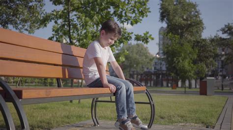 Sad Lonely Little Boy Sitting On The Bench In The Park Cute Child