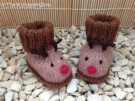 A Pair Of Knitted Slippers Sitting On Top Of Rocks