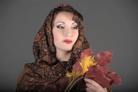 Portrait Of A Beautiful Dark Haired Woman With A Scarf On Her Head And Autumn Leaves Stock Image