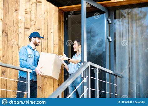 Delivery Man Bringing Goods Home For A Woman Client Stock Photo Image
