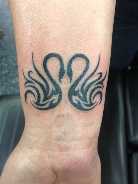 cool tribal double black ink swans tattoo on wrist tattooimages