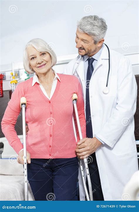 Senior Patient Being Helped By Doctor With Crutches Stock Image Image