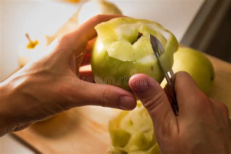 Female Hands Peeling Skin Off Of Green Apple Using A Paring Knife Stock