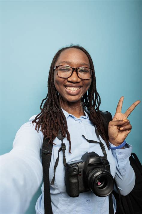 Happy Smiling Photographer With Modern Camera Device Giving Peace Sign