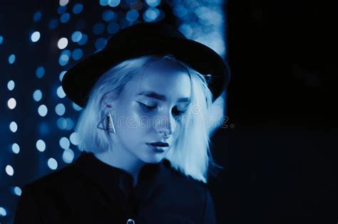 Millennial Enigmatic Pretty Girl Blond Hairstyle Near Blue Glowing Neon