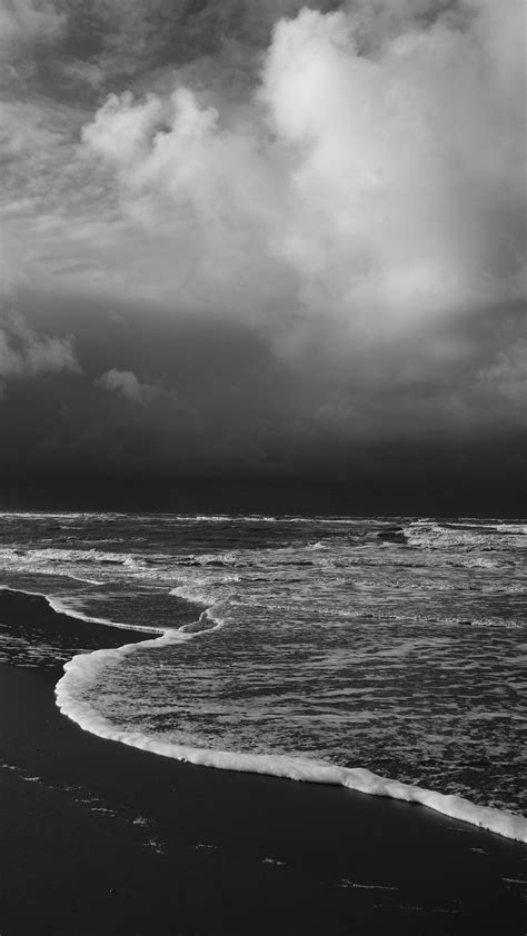 Black And White Image Of Beach Ocean Waves Under White Clouds Black Sky