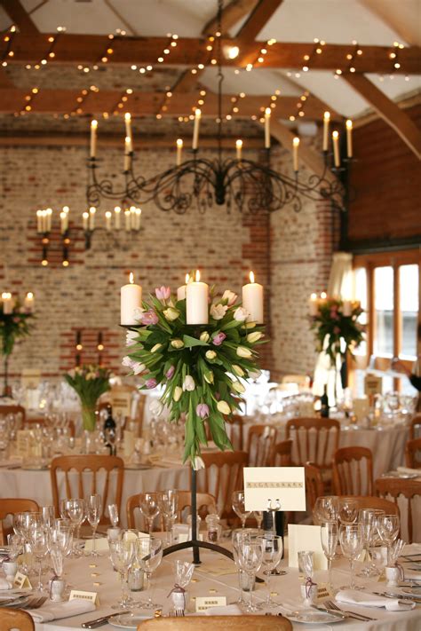 The beautifully detailed wrought iron design is the inspiration for this lovely, sophisticated wedding invitation. Upwaltham Barn decorated with our wrought iron candelabra adorned with tulips - image by Danni ...