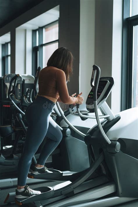 Young Brunette Woman Training For Cardio Equipment At Fitness Gym Stock Image Image Of