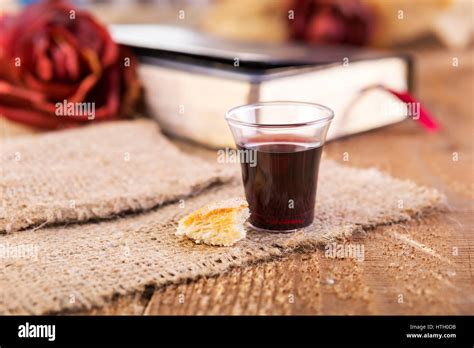 Taking Communion. Cup of glass with red wine, bread and Holy Bible on