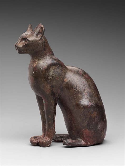 A Bronze Statue Of A Cat Sitting On The Ground