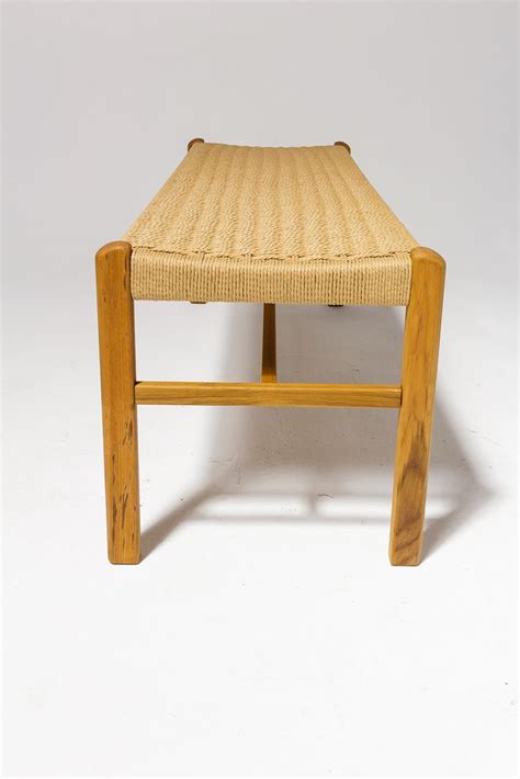 The woven rattan structure of the bench generates a dynamic surface with which to interact. AB057 Chester Woven Rattan Bench Prop Rental | ACME Brooklyn
