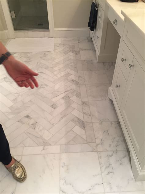 Slate herringbone pattern floor tiles in a transitional bathroom includes a seamless glass shower with large white and gray marble staggered wall tiles. herringbone pattern inset surrounded by 12x12 white ...
