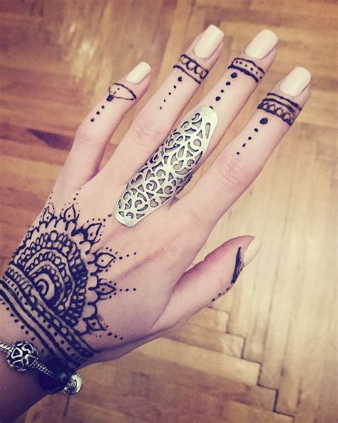 A Woman S Hand With Henna Tattoos And Rings On Her Left Wrist