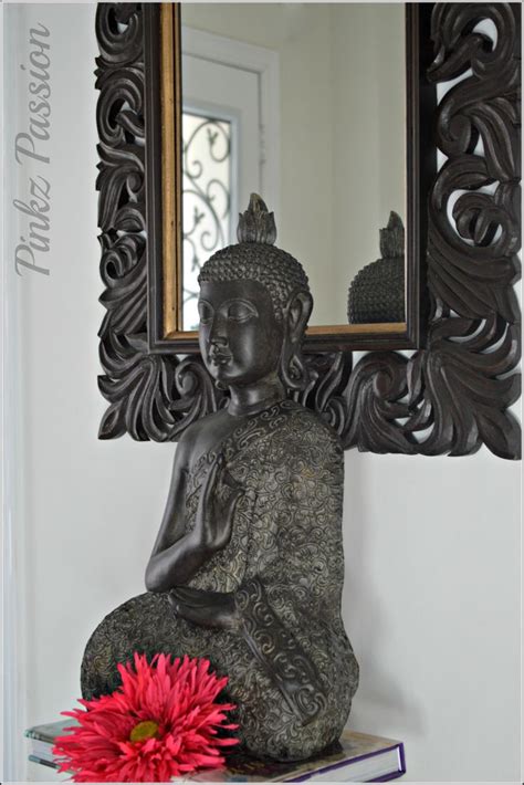 Home decor with a gold statue of buddha against a black wall with an ethnic pattern of stones. Buddha décor at the entrance, Buddha paired with mirror ...