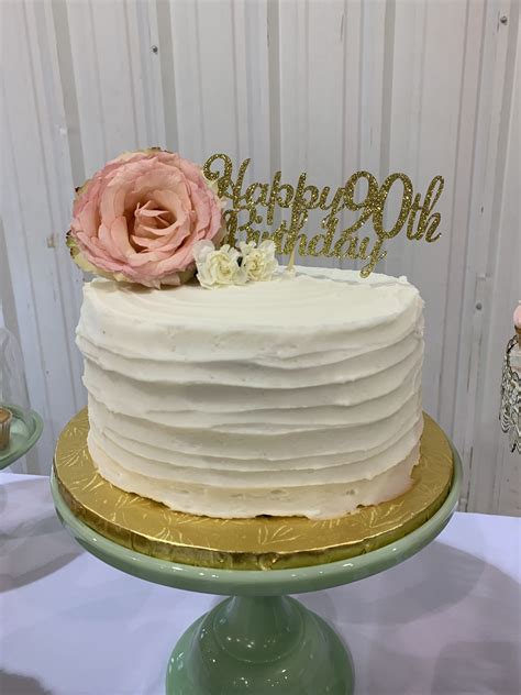There Is A White Cake With Pink Flowers On The Top And Gold Trimmings