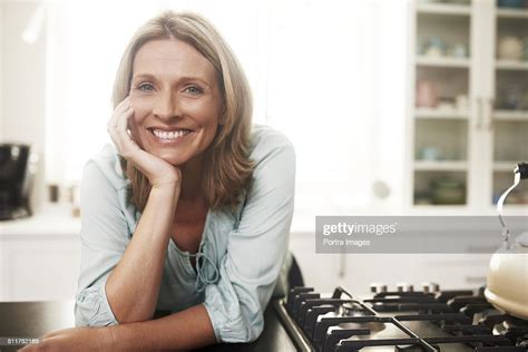 Happy Woman Leaning On Kitchen Counter Photo Getty Images