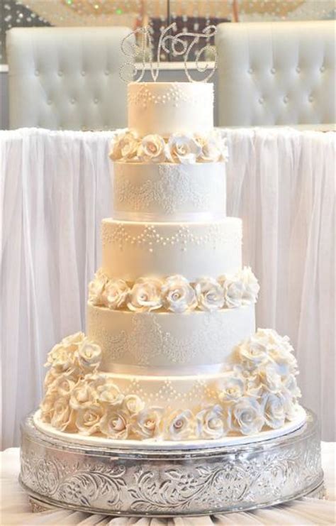 Ivory and white wedding cake. Five tier elegant ivory wedding cake with white roses and ...