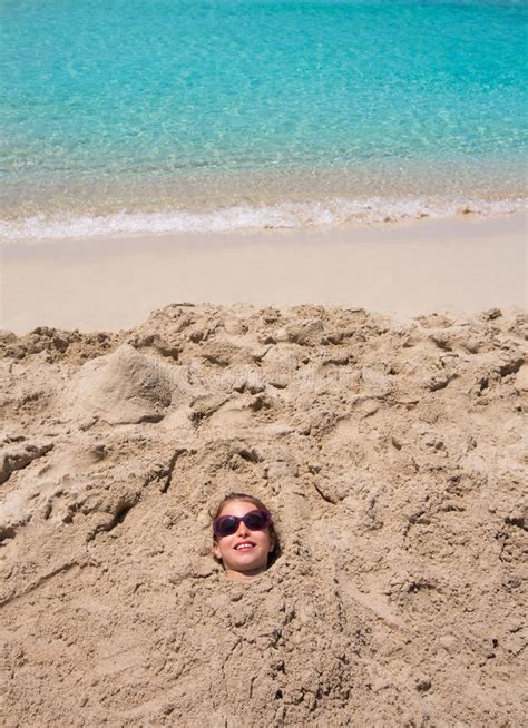 Funny Girl Playing Buried In Beach Sand Smiling Sunglasses Stock Photo
