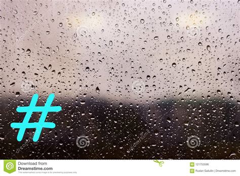 Water Drops From Rain On The Window Glass Against The Urban Landscape With A Hashtag Stock