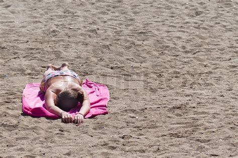 A Woman Lies On A Sandy Beach To Tan In Stock Image Colourbox