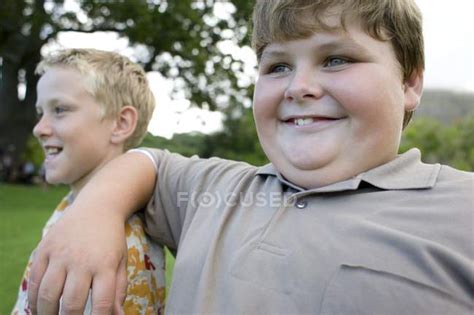 Elementary Age Obese Boy Leaning On Friend Shoulder — Overweight
