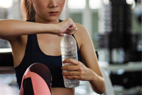 Young Athletic Fitness Woman Drinking Water From Bottle In Gym Stock